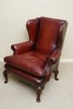 A classic Georgian style walnut wingback hand-dyed leather chair